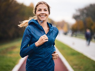 Woman smiling while running in park