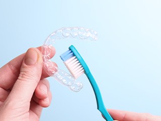 Patient cleaning clear aligner with toothbrush